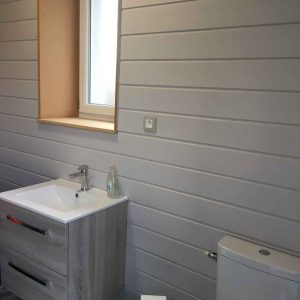 Salle de bain moderne dun hébergement insolite en Bourgogne, avec meuble en bois clair.