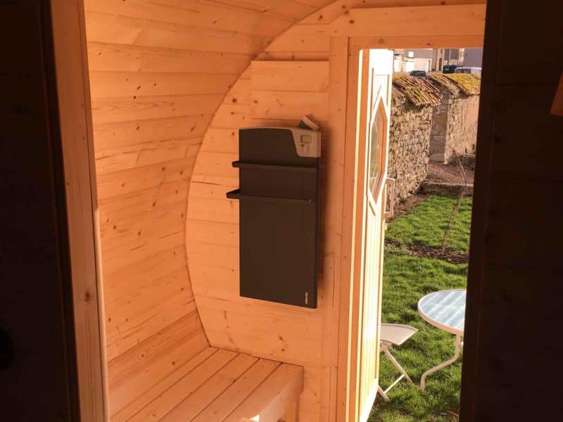 Cabane en bois avec intérieur chaleureux et vue sur un jardin verdoyant.