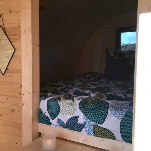 Hébergement insolite en Bourgogne : un cocon en bois avec lit douillet et décor coloré.