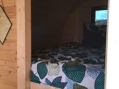 Hébergement insolite en Bourgogne : un cocon en bois avec lit douillet et décor coloré.