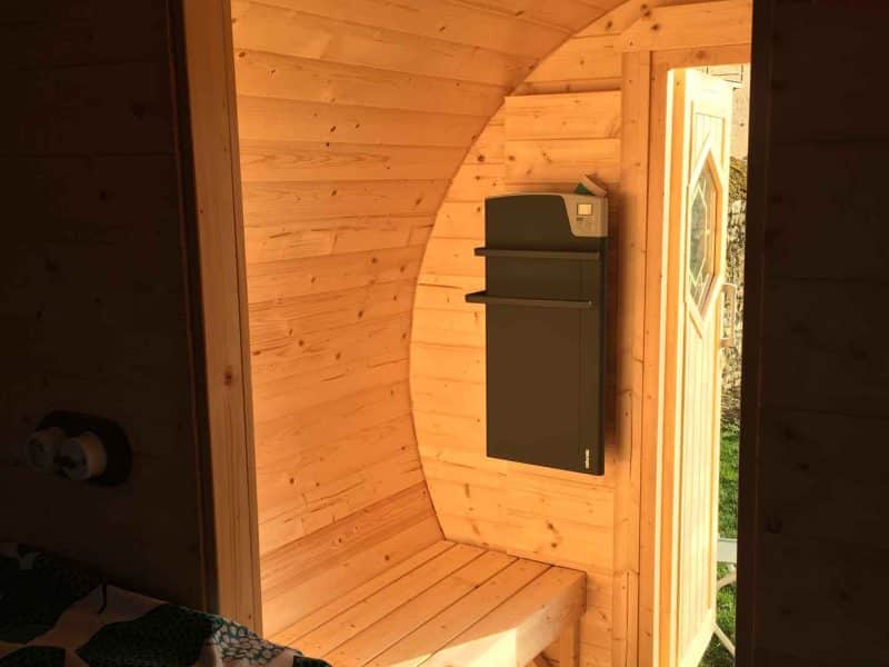 Cabane en bois avec intérieur chaleureux et porte ouverte sur lextérieur.