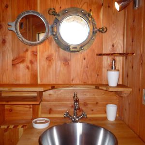 Lavabo en métal dans un hébergement insolite en bois en Auvergne-Rhône-Alpes.