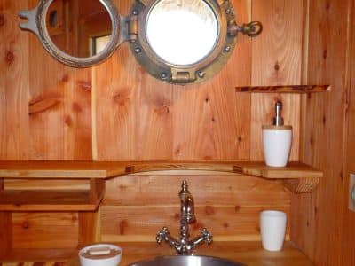 Lavabo en métal dans un hébergement insolite en bois en Auvergne-Rhône-Alpes.