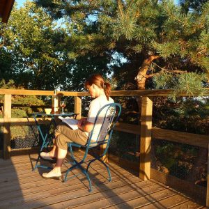 Cabane perchée en Auvergne-Rhône-Alpes, avec terrasse en bois et vue sur la nature.