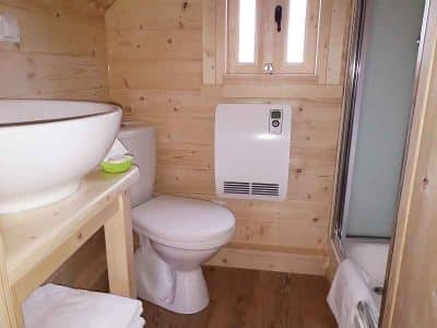 Cabane en bois en Auvergne, avec salle de bain moderne et lavabo design.