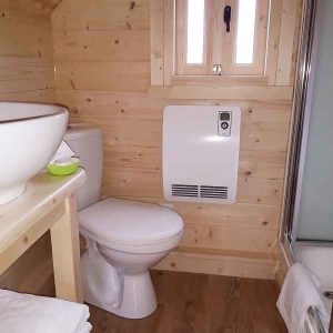 Cabane en bois en Auvergne avec salle de bain moderne et lumière naturelle.