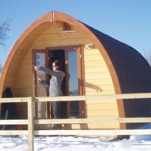Cabane en bois à Auvergne, avec un toit arrondi et une vue sur la neige.