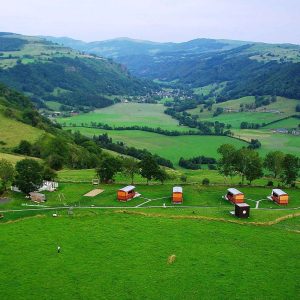 Hébergement insolite en Auvergne : cabanes colorées au milieu dun paysage verdoyant.
