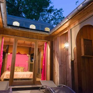 Hébergement insolite en Aquitaine : cabane en bois avec lumière tamisée et décoration colorée.
