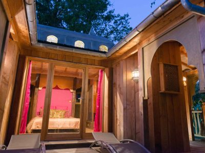 Hébergement insolite en Aquitaine : cabane en bois avec lumière tamisée et décoration colorée.