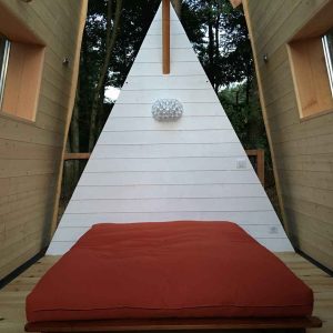 Hébergement insolite en Aquitaine : cabane en bois avec un lit confortable et un design moderne.
