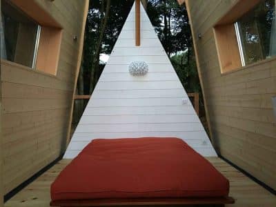 Hébergement insolite en Aquitaine : cabane en bois avec un lit confortable et un design moderne.