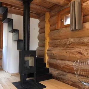 Cabane en bois dans lAquitaine, avec un poêle moderne et des escaliers en colimaçon.