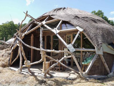 Hébergement insolite en forme de dôme, avec une structure en bois et toit de chaume.