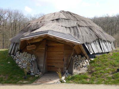 Hébergement insolite en forme de yourte, avec un toit en chaume et une entrée en bois.