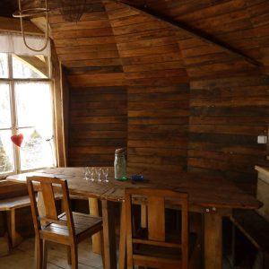 Cabane en bois dans le Grand-Est, avec un intérieur chaleureux et une table en bois.