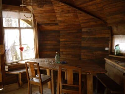Cabane en bois dans le Grand-Est, avec un intérieur chaleureux et une table en bois.