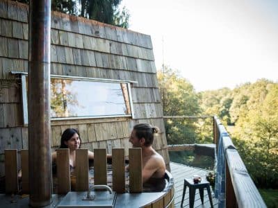 Cabane en bois avec jacuzzi extérieur, vue sur la nature en Aquitaine.