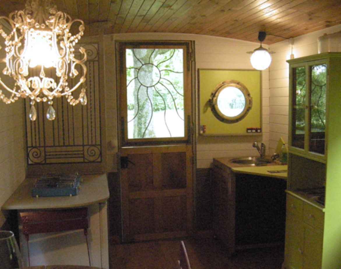 Hébergement insolite en Bourgogne : intérieur cosy avec lustre et cuisine colorée.