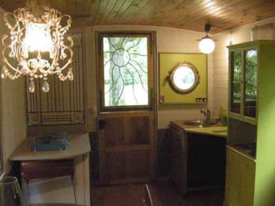 Hébergement insolite en Bourgogne : intérieur cosy avec lustre et cuisine colorée.