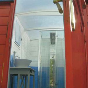 Hébergement insolite en Bourgogne : cabane colorée avec douche moderne et vue dégagée.