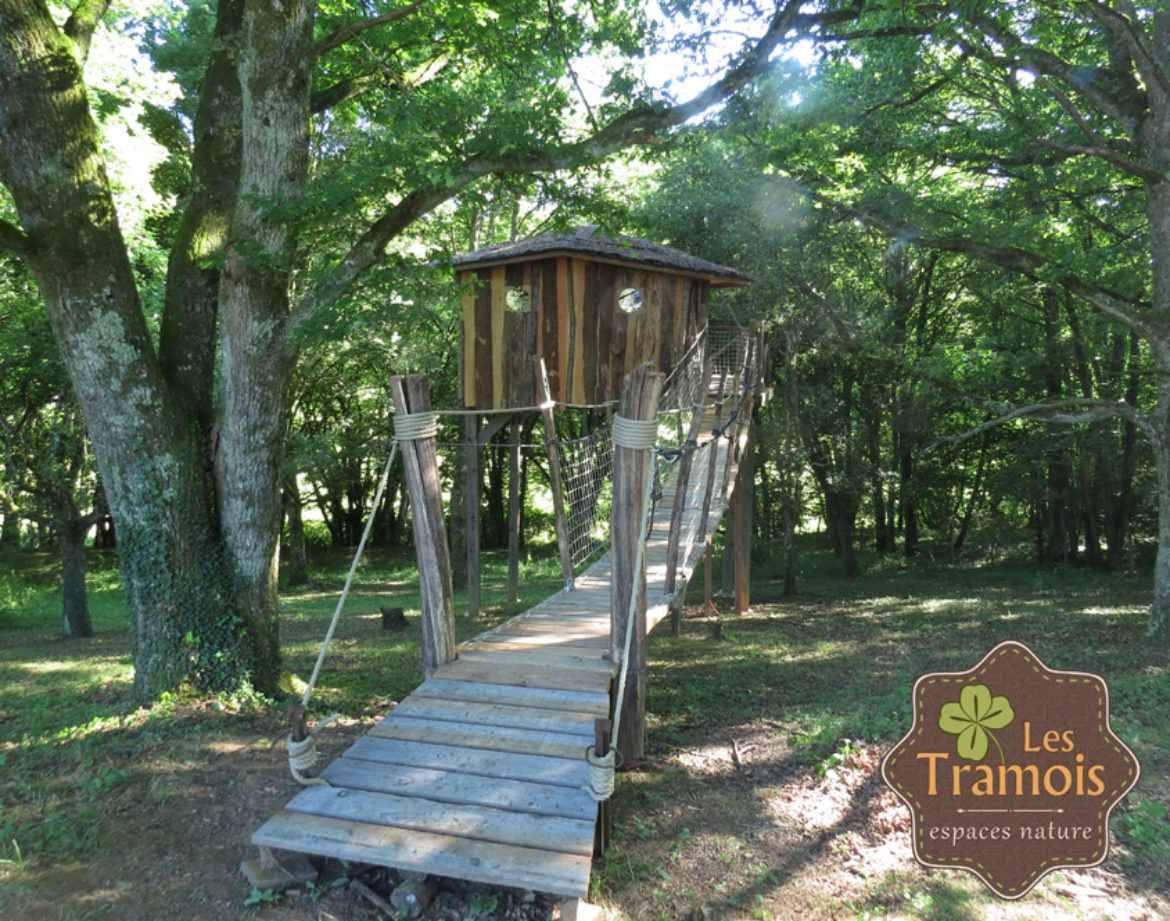 Cabane perchée en bois, accessible par un pont suspendu, au cœur de la nature en Bourgogne.