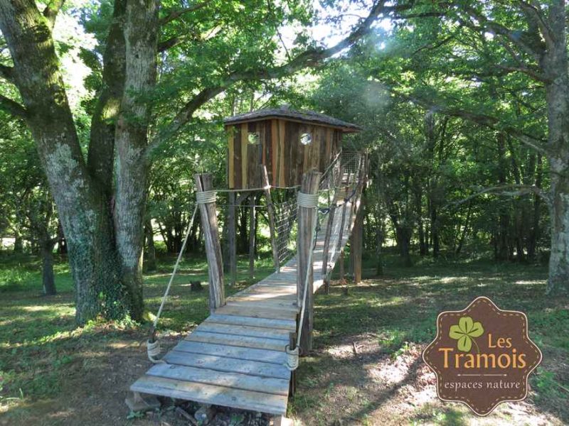 Cabane perchée en bois, accessible par un pont suspendu, au cœur de la nature en Bourgogne.