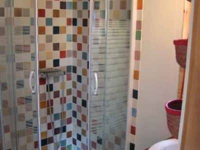 Douche colorée dans un hébergement insolite en Bourgogne, ambiance chaleureuse.