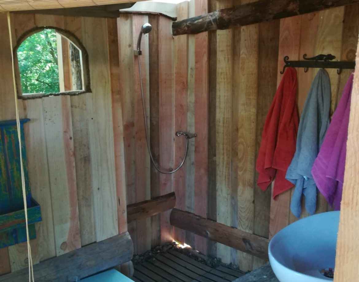 Douche en bois dans un hébergement insolite en Bourgogne, ambiance naturelle et chaleureuse.