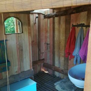 Douche en bois dans un hébergement insolite en Bourgogne, ambiance naturelle et chaleureuse.