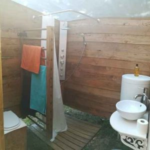 Douche extérieure en bois dans un hébergement insolite en Bourgogne.
