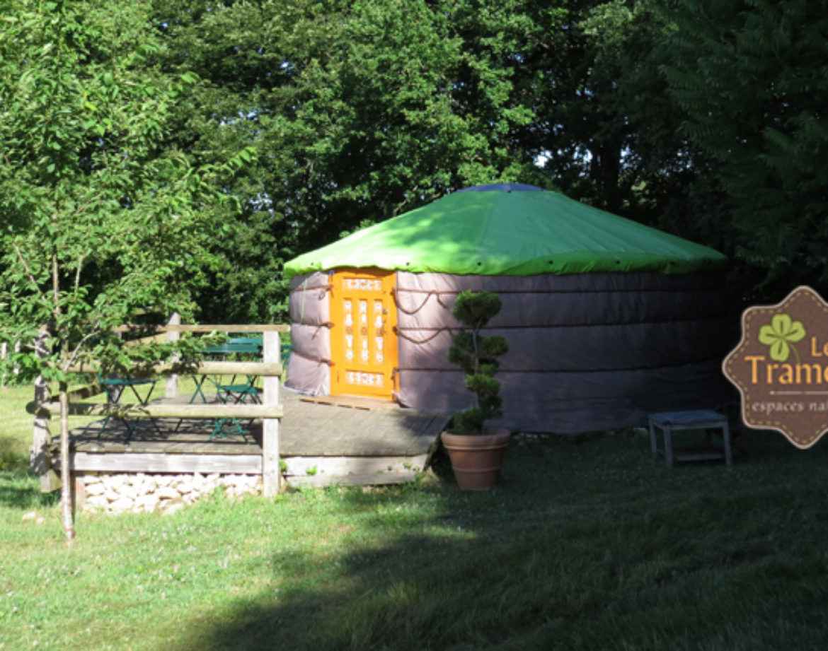 Yourte colorée avec toit vert, entourée de verdure à Bourgogne. Hébergement insolite.