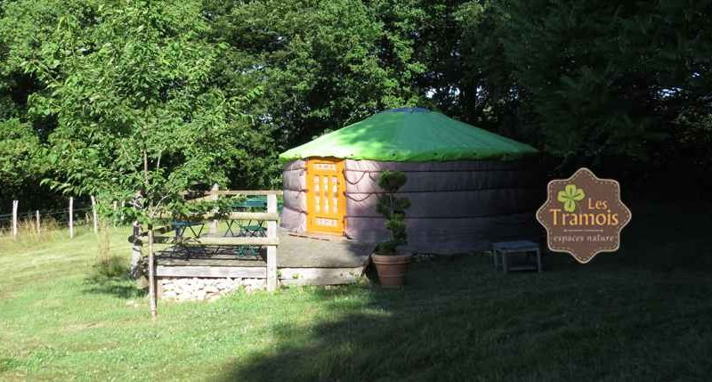 Yourte colorée avec toit vert, entourée de verdure à Bourgogne. Hébergement insolite.