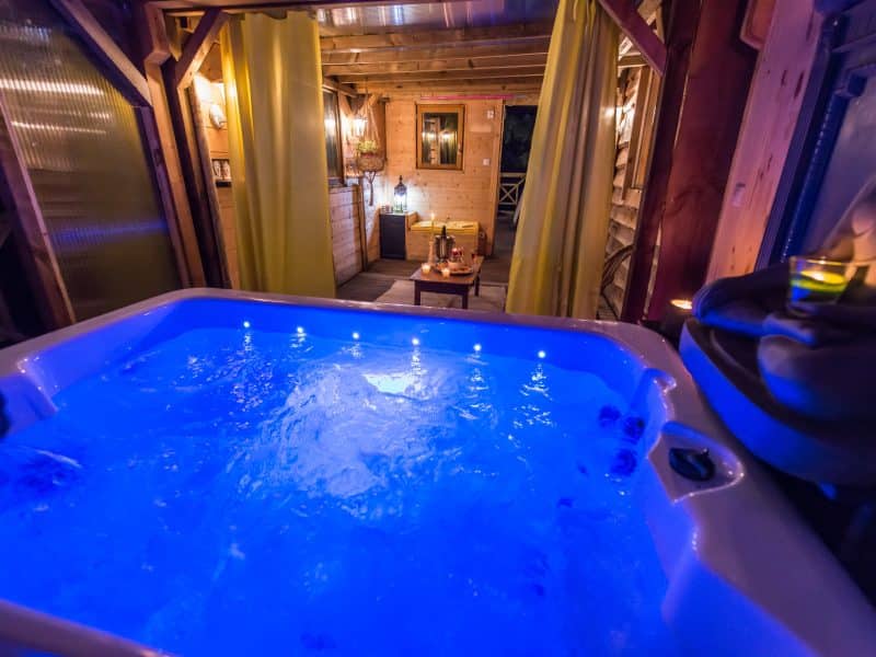 Chalet romantique avec jacuzzi lumineux, ambiance chaleureuse et intime.