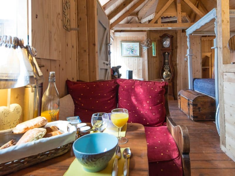 Chalet en bois chaleureux avec petit-déjeuner sur une table en bois.