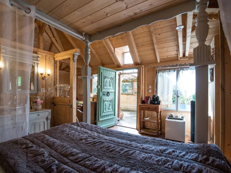Chalet en bois chaleureux avec lit douillet et porte décorative.
