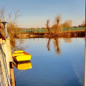 Hébergement insolite en Bourgogne : cabane sur leau avec un canot jaune au bord.