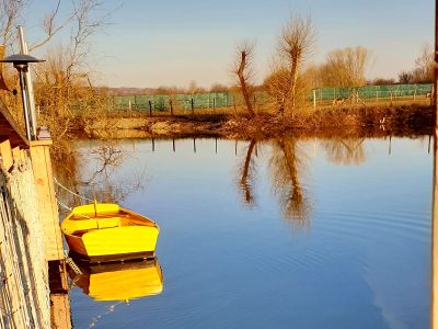 Hébergement insolite en Bourgogne : cabane sur leau avec un canot jaune au bord.