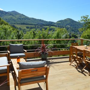 Hébergement insolite en Midi-Pyrénées avec terrasse en bois et vue sur les montagnes.