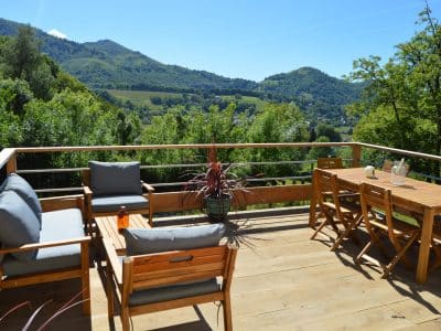 Hébergement insolite en Midi-Pyrénées avec terrasse en bois et vue sur les montagnes.