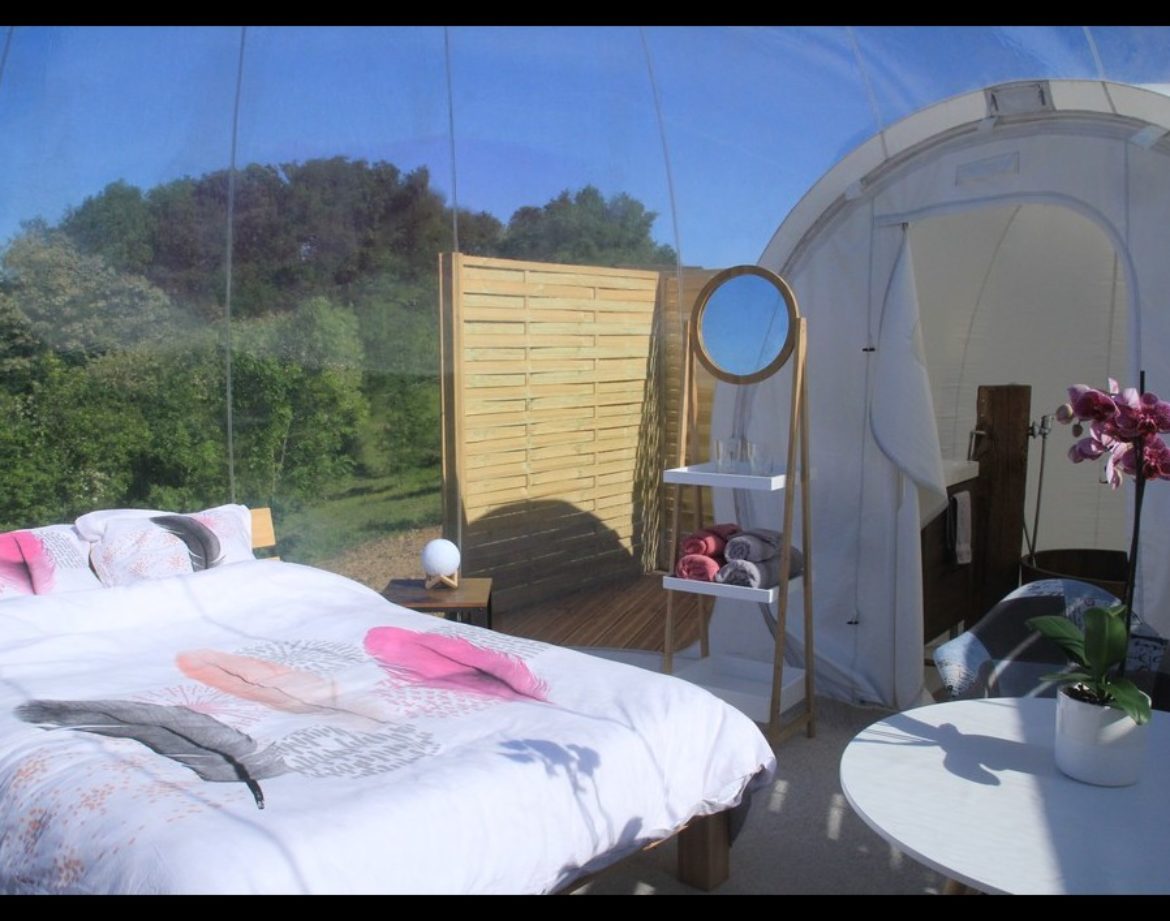 Hébergement insolite en bulle transparente, lit douillet et vue sur la nature.