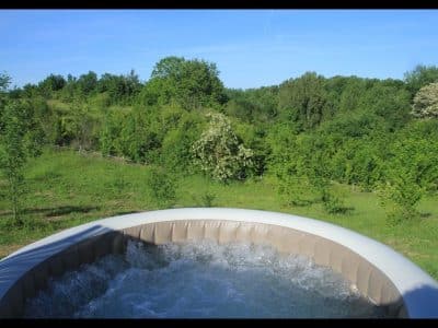 Hébergement insolite en Midi-Pyrénées avec jacuzzi et vue sur la verdure environnante.