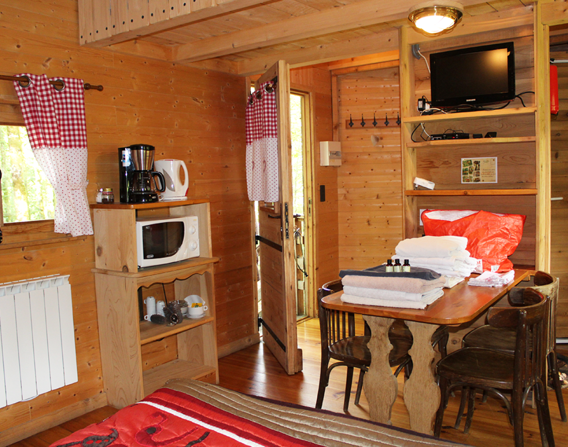 Cabane en bois cosy avec kitchenette et décor chaleureux en Bourgogne-Franche-Comté.