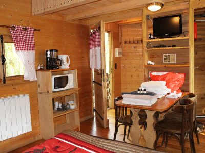 Cabane en bois cosy avec kitchenette et décor chaleureux en Bourgogne-Franche-Comté.