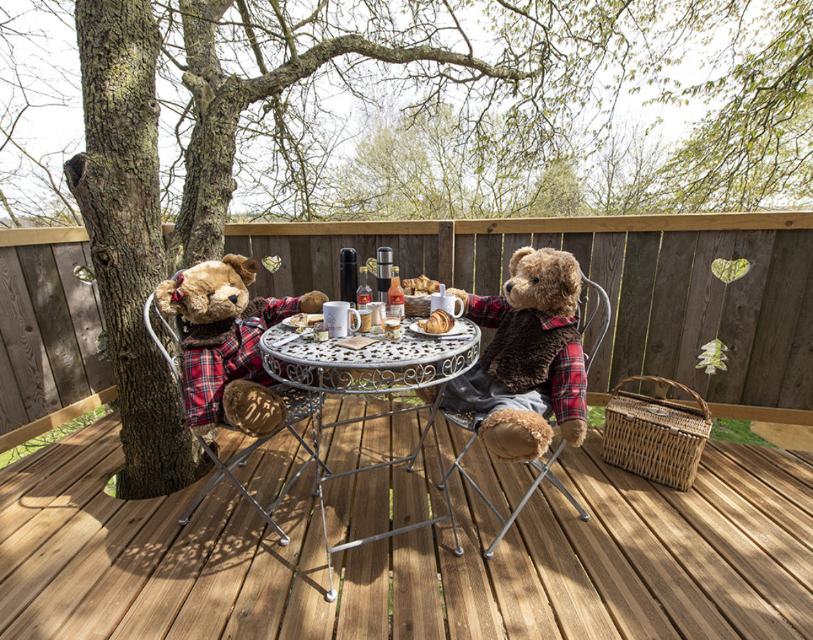 Hébergement insolite en Hauts-de-France : oursons en peluche autour dune table en bois.