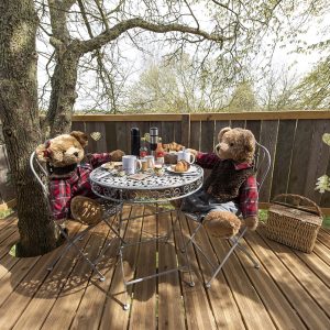 Hébergement insolite en Hauts-de-France : oursons en peluche autour dune table en bois.