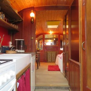 Intérieur dune péniche cosy avec cuisine équipée et décoration chaleureuse.