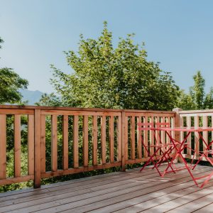 Terrasse en bois avec chaises rouges, hébergement insolite en Provence-Alpes-Côte dAzur.