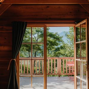 Cabane en bois avec vue sur la nature, baignée de lumière et ambiance chaleureuse.