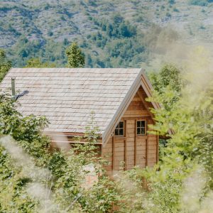 Cabane en bois nichée dans la verdure, avec vue sur les montagnes en Provence-Alpes-Côte dAzur.